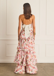 Woman wearing a floral dress with a white wall background